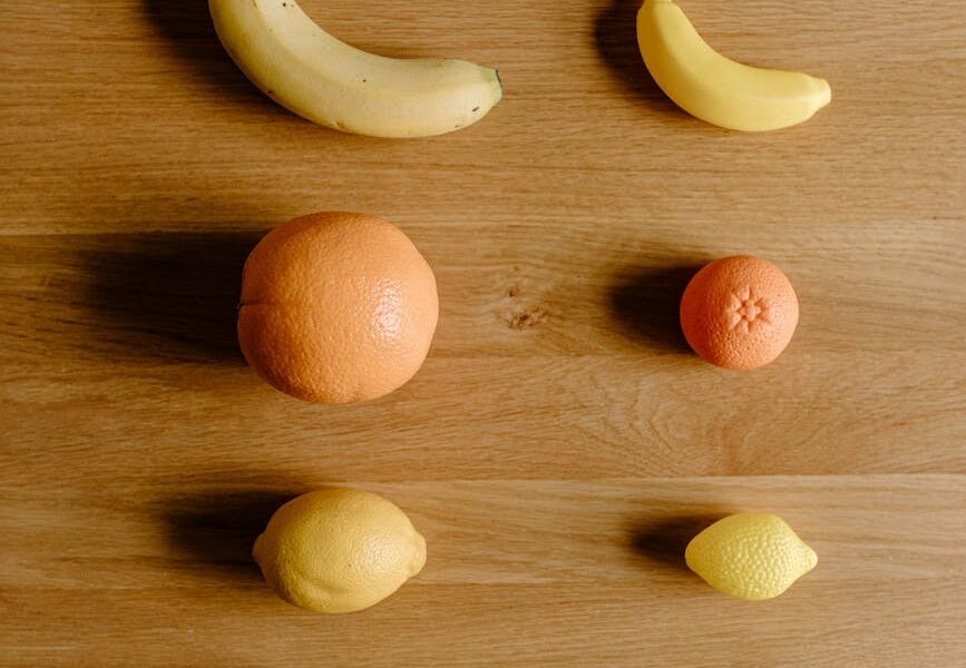 citruses and bananas placed on wooden surface